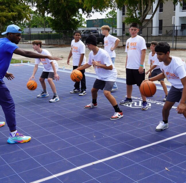 JAYLEN WHITE DEMONSTRATES PROPER DRIBBLING TECHNIQUES DURING A BASKETBALL CLINIC ON THE NEW DREAM COURT AT PARK MEADOWS COMMUNITY CLUB