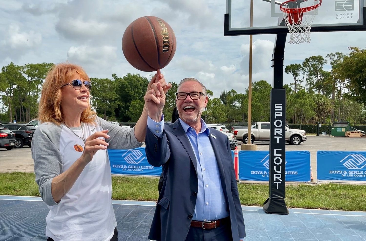 BASKETBALL HALL OF FAMER NANCY LIEBERMAN SHOWS FORT MYERS MAYOR KEVIN ANDERSON HOW TO SPIN A BASKETBALL ON HIS FINGER