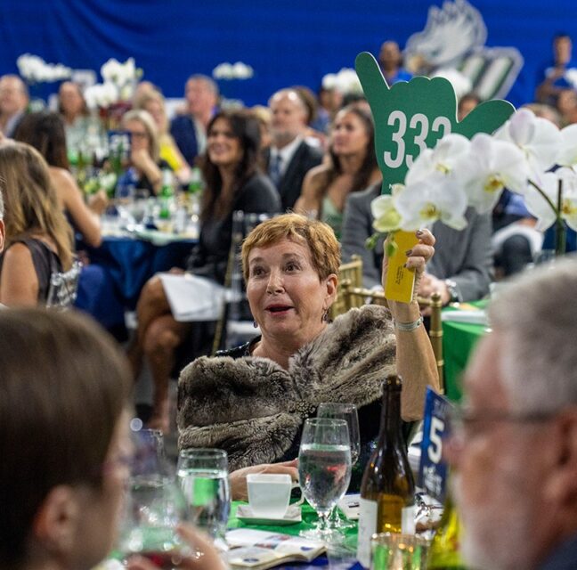 Guest raises bid paddle 333 during the auction at FGCU's Night at the Nest Gala
