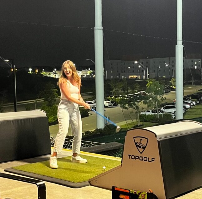Guest mid-swing in a bay at Topgolf Fort Myers during the KLCB fundraiser