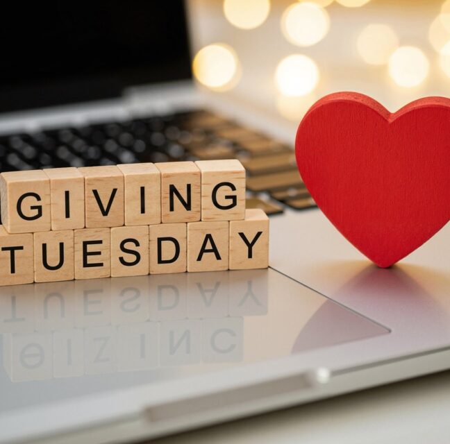 Giving Tuesday spelled in wooden blocks beside a red heart on a laptop