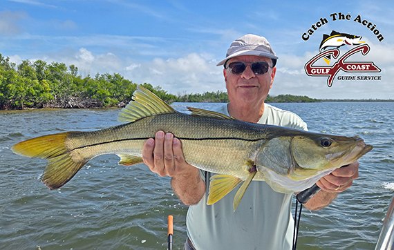 Capt. Bill Russell holding a large snook on the water
